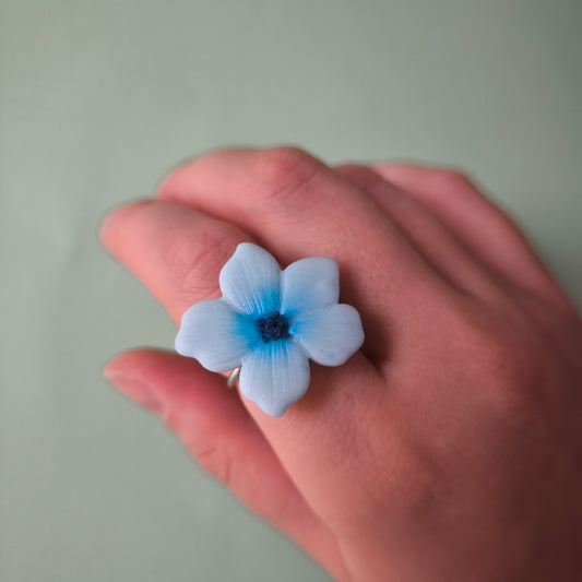 anillo regulable con charm artesanal floral Lupe en arcilla polimérica, hecho en España. Acero inoxidable. Livianos. Stock limitado. celeste