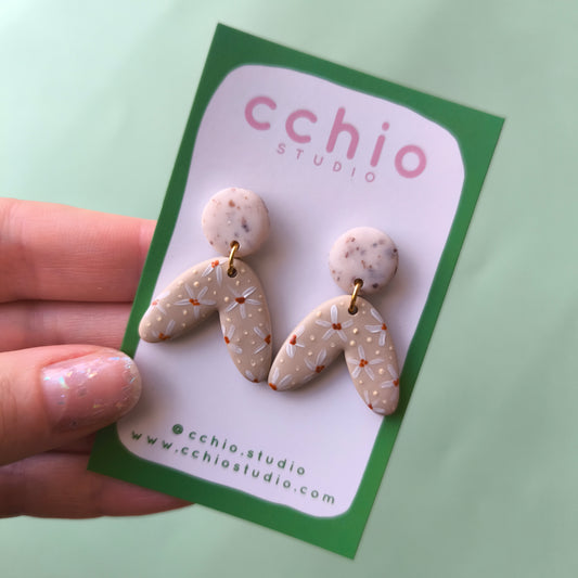 Pendientes pintados a mano beige y colorado con flores blancas