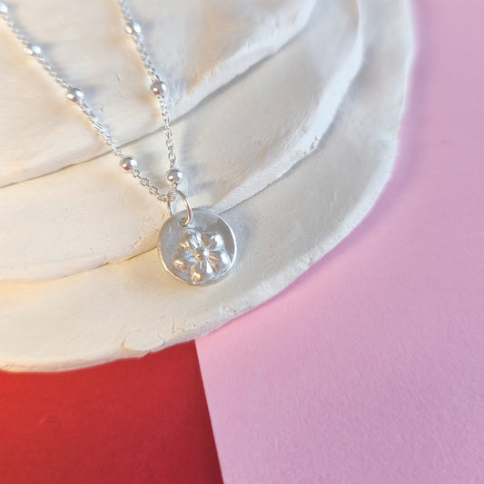 Colgante artesanal Lupe circular con flor de plata