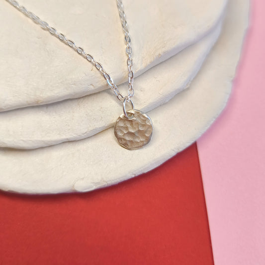 Colgante artesanal Ona circular martillado de plata